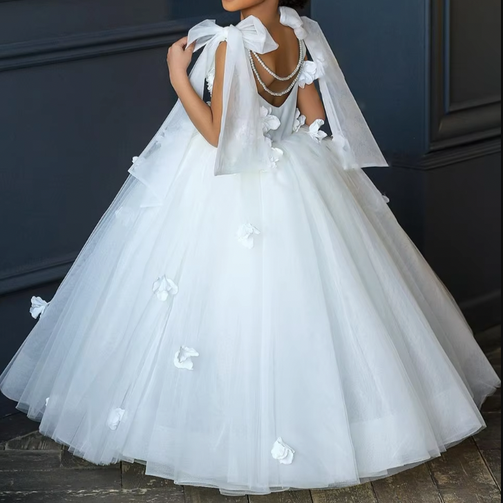 Flower girl princess dress in elegant white, adorned with delicate 3D flowers and a pearl necklace detail at the back. Features tie-up silk sleeves and a graceful low-back cut, perfect for a charming and sophisticated look.